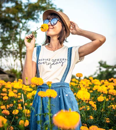 Un particulier qui hume une fleur jaune , pour retrouver son étincelle d'audace avec Delphine Wolf , coach Bulle